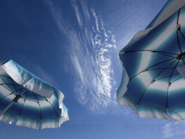 Parasols in front of a blue sky with clouds