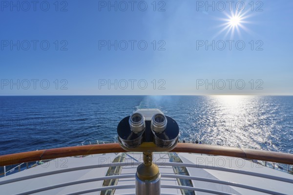 View from the ship's deck, Mein Schiff 6, under bright sunshine and blue sky, binoculars installed at the stern, North Sea, Norway, Europe