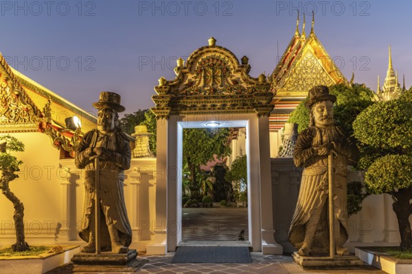 Huge Farang Guard fortifications at the entrance to the Buddhist temple Wat Pho at dusk, Bangkok, Thailand, Asia
