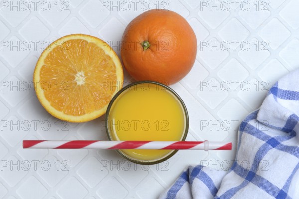 Orange juice in glass and orange, straw