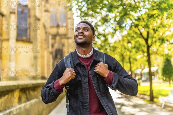 African man smiling while exploring walking down a city