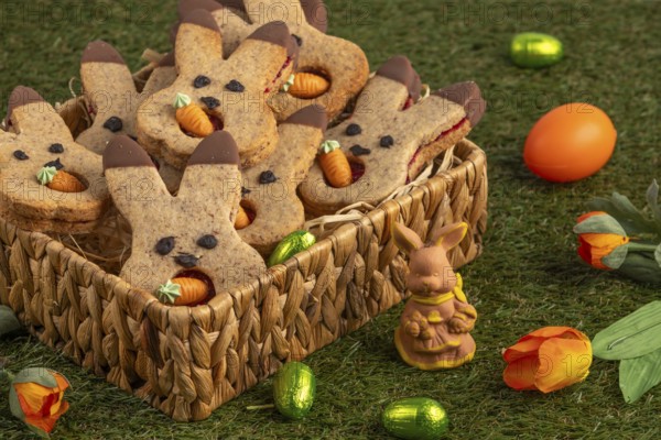 Bunny biscuits in a basket next to Easter decorations in a meadow