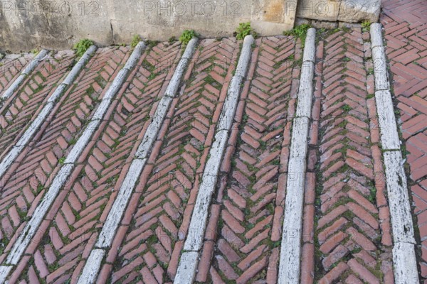 Brick-paved slope in the cathedral square in the medieval town of San Gimignano, province of Siena, Tuscany, Italy, Europe