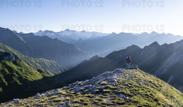 Hiker enjoying the mountain panorama in the morning, Venediger group, behind Dreiherrenkopf, Simonysitze and Großer Geiger, Hohen Tauern, Austria, Europe