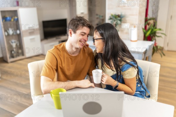 Young multi ethnic couple enjoying a quiet moment together at their home, sharing coffee and affection