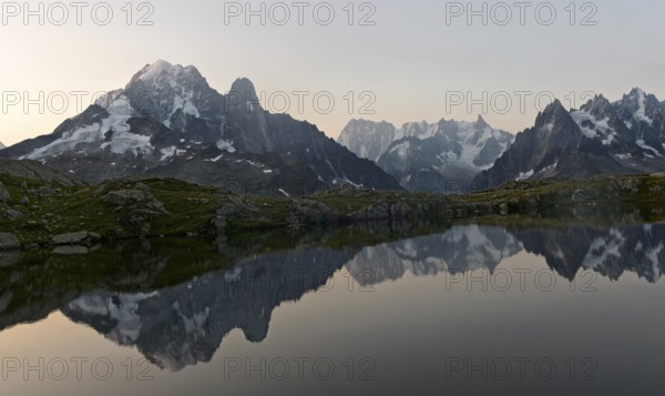 Dusk at the Lacs des Chéserys mountain lake in the Aiguilles Rouges nature reserve, with the Aiguille Verte, Aiguille du Dru and Grandes Jorasses peaks behind, Chamonix, Haute Savoie, France, Europe