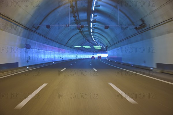 Modern, well-lit motorway tunnel with blue illuminated walls and a clear asphalt road, Zurich, Switzerland, Europe
