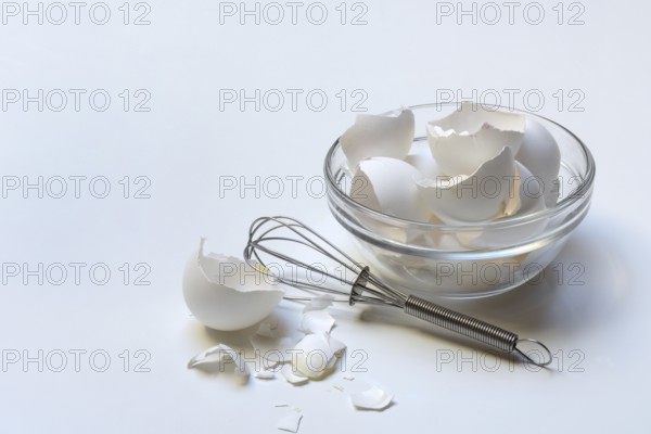 Egg shells in glass bowl and whisk