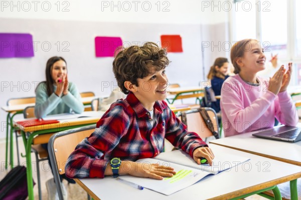 Elementary school students sitting at desks, attentively listening to the teacher while taking notes during an engaging classroom lesson