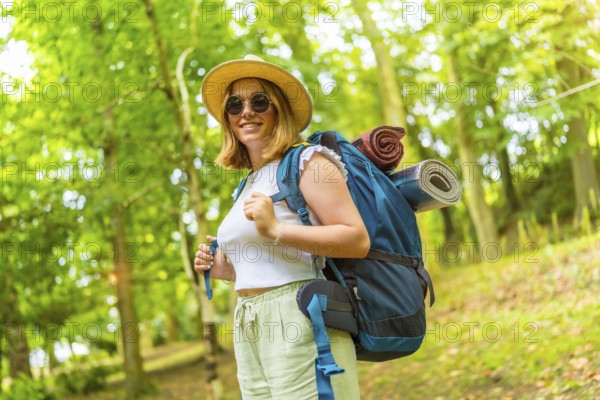 Portrait of young caucasian woman while walking in green forest and enjoy the beauty of nature