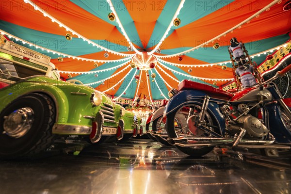 Carousel with reflective lights and colourful vehicles, Christmas market Ludwigsburg, Germany, Europe