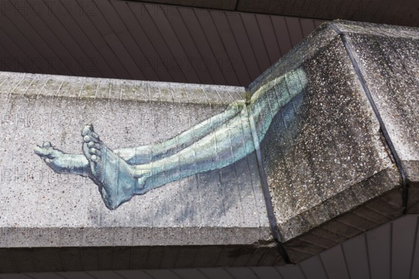 Human legs protruding from a concrete façade, surreal graffiti on the Seidenweberhaus, Brutalist-style building, Krefeld, North Rhine-Westphalia, Germany, Europe