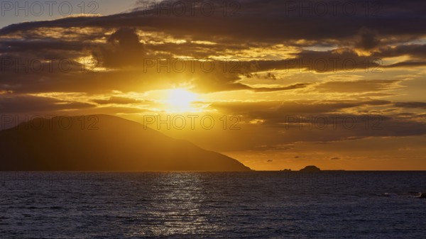 Dramatic golden sunset over the sea with clouds and an island in the background, sunset, Kassos, Karpathos, offshore islands, Dodecanese, Greek Islands, Greece, Europe