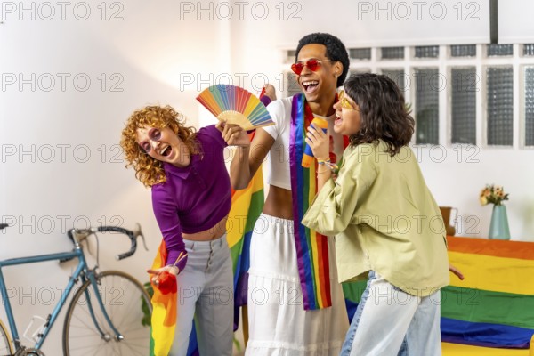 Multi-ethnic friends celebrating pride with rainbow hand fan and flags having fun at home