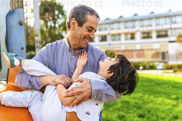 Grandfather and grandson enjoying playful moments together at the park, sharing laughter and creating cherished memories in the sunshine