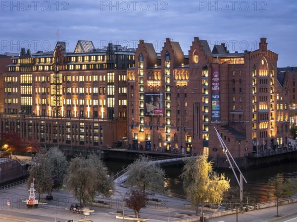 Aerial view of the International Maritime Museum Hamburg surrounded by trees during the blue hour at dusk, Speicherstadt, Hamburg, Germany, Europe