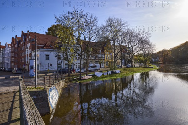 Riverbank of the Trave, pedestrian bridge Dankwartsbrücke, trees, historic houses, reflections on the water surface, Old Town, Hanseatic City of Lübeck, independent city, Schleswig-Holstein, Germany, Europe