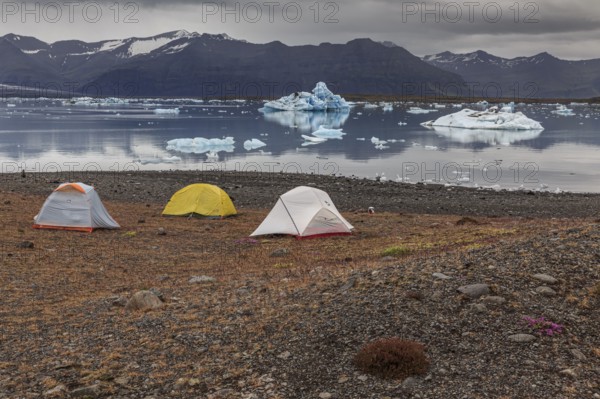 Tents in front of glacier lagoon, icebergs, camping, mountains, cloudy, winter, Jökulsarlon, Iceland, Europe