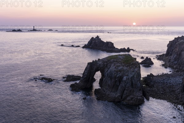 Coastal landscape at Land's End. The Enys Dodnan Arch with rock gate. In the evening at sunset. Land's End, Penzance, Cornwall, England, Great Britain