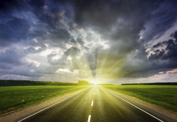 Travel concept background, road and stormy dramatic sky on sunset