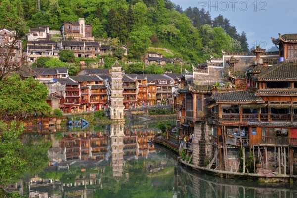 Chinese tourist attraction destination, Feng Huang Ancient Town (Phoenix Ancient Town) on Tuo Jiang River with Wanming Pagoda tower on sunset. Hunan Province, China, Asia