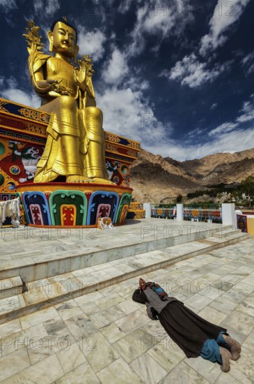 Tibetan Buddhist woman worshiping and praying Buddha Maitreya statue in Likir gompa (monastery), Ladakh, India, Asia