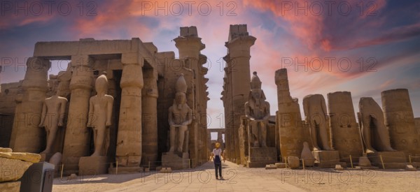 Sculptures of ancient Egyptian pharaohs and drawings on the columns of the Luxor Temple in the evening. Egypt