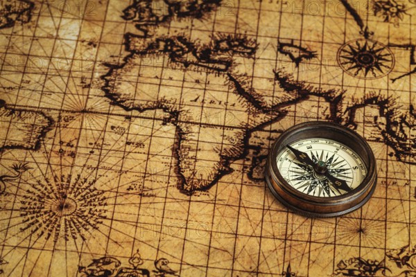 Travel geography navigation concept background, old vintage retro compass on ancient world map