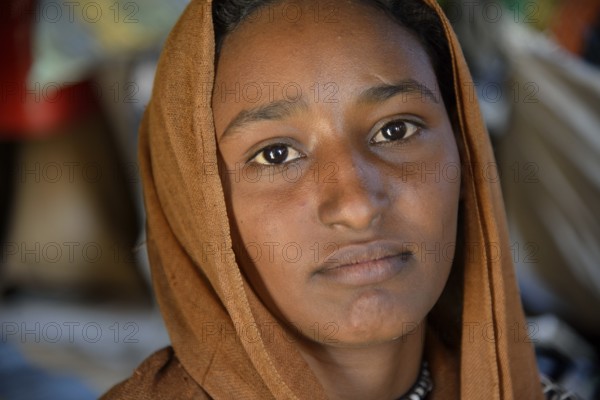 Young girl from a nomadic tribe, wearing headgear, portrait, Bayuda Desert, in Karima, Nubia, Northern Sudan, Sudan, Africa