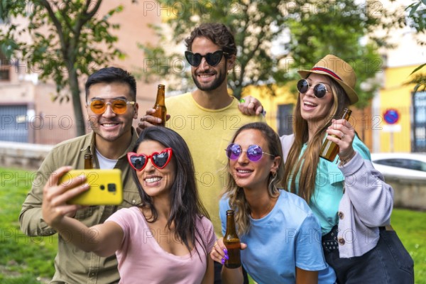 Multi ethnic group of friends partying in the city park taking a selfie, friendship and fun concept with sunglasses