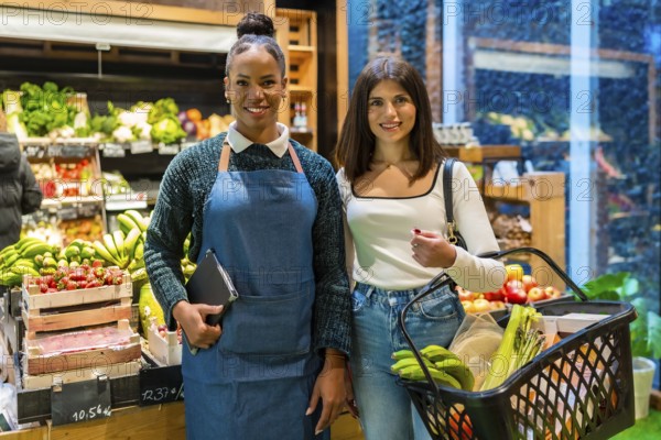 Supermarket employee and customer posing together in a grocery store full of fresh bio products