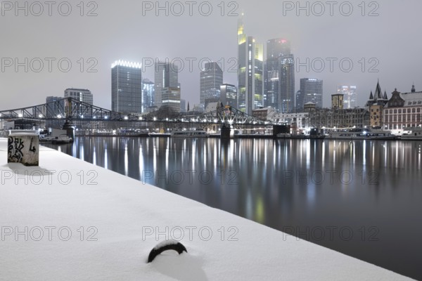 The skyscrapers of Frankfurt's banking skyline rise up from the snow-covered city centre into the low-hanging cloud cover