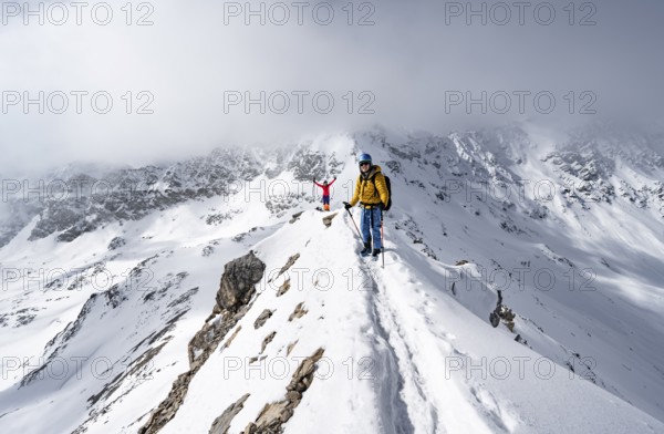 Two mountaineers climbing up the narrow mountain ridge of Piz Laviner, view of wintry mountain landscape, Grisons Haute Route, Albula Alps, Rhaetian Alps, Grisons, Eastern Switzerland, Switzerland, Europe