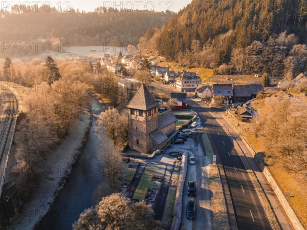 Village with church by the river, surrounded by autumnal forest in a warm sunrise, Kentheim, district of Calw, Black Forest, Germany, Europe