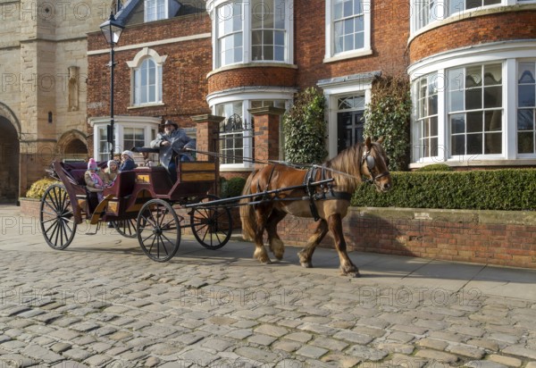 Horse and carriage ride passing houses in Minster Yard of Lincoln cathedral, city of Lincoln, Lincolnshire, England, UK