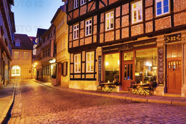 Half-timbered houses in a cobbled street, old town centre in the evening, World Heritage City of Quedlinburg, Saxony-Anhalt, Germany, Europe