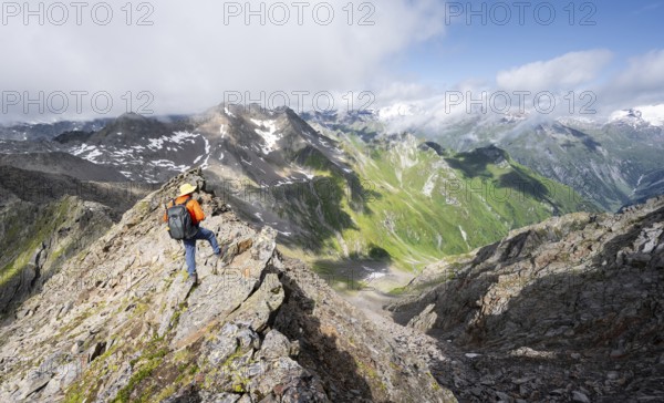 Mountaineer on a steep rocky ridge, on the summit of the Lasörling, view of the mountain panorama of the Venediger Group, Lasörling Group, Hohe Tauern National Park, East Tyrol, Tyrol, Austria, Europe