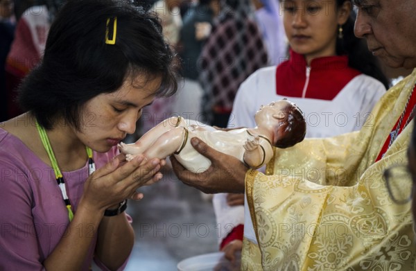 Archbishop John Moolachira holds an idol of baby Jesus Christ as devotees kiss the idol during a Christmas day sermon on December 25, 2024 in Guwahati, India. Christmas is a festive holiday celebrated on December 25th, marking the birth of Jesus Christ in Christian tradition.