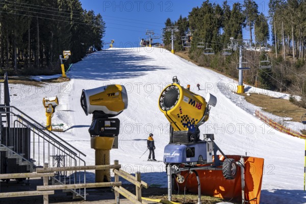 Winter sports area in the Sauerland, Winterberg ski lift carousel, artificial snow slopes, artificial snow from over 360 snow guns, Poppenberg ski area, quick jet lift, 12 of 24 lifts are in operation in mid-March, the rest of the landscape is snow-free, North Rhine-Westphalia, Germany, Europe