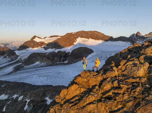 Atmospheric sunrise in a picturesque mountain landscape, alpenglow, aerial view, mountaineer on the summit of Becher and Übeltalferner glacier, Stubai Alps, South Tyrol, Italy, Europe
