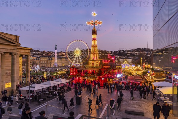Stuttgart Christmas market at the blue hour. Christmas pyramid on Schlossplatz in front of the New Palace with Ferris wheel. The traditional event attracts more than three and a half million people to the city centre during the Christmas season. Stuttgart, Baden-Württemberg, Germany, Europe