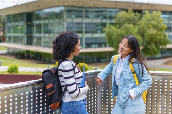 Horizontal photo with copy space of two smiling multiracial woman talking in the university campus