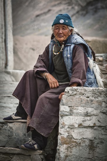LAMAYURU, INDIA, SEPTEMBER 10, 2011: Old tibetan woman sitting near Lamayuru gompa in Ladakh, India, Asia