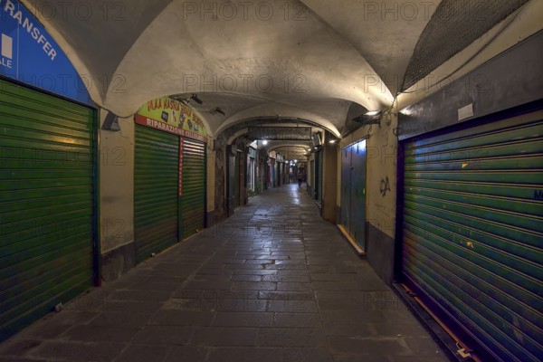 Closed shops in the old arcades at the harbour at night, Genoa, Italy, Europe
