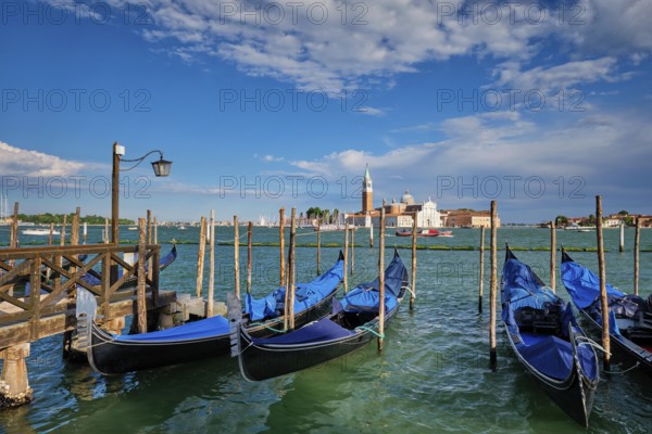 Gondolas and in lagoon of Venice by Saint Mark (San Marco) square with San Giorgio di Maggiore church in background in Venice, Italy, Europe