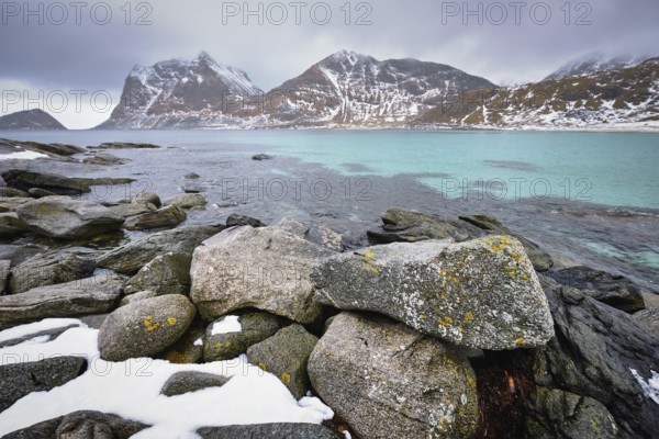 Rocky coast of fjord of Norwegian sea in winter with snow. Haukland beach, Lofoten islands, Norway, Europe