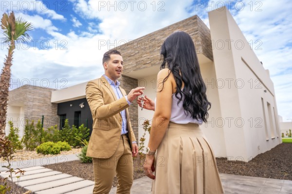 Woman receiving the keys of a new house outside the building