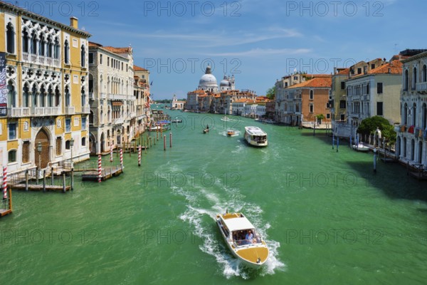 VENICE, ITALY, JULY 19, 2019: View of Venice Grand Canal with boats and Santa Maria della Salute church in the day from Ponte dell'Accademia bridge. Venice, Italy, Europe