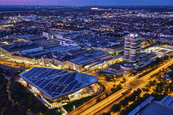 MUNICH, GERMANY, JULY 08, 2018: Aerial view of BMW Museum and BWM Welt and factory and Munich from Olympic Tower illuminated at night. BMW is a famous German luxury car automaker