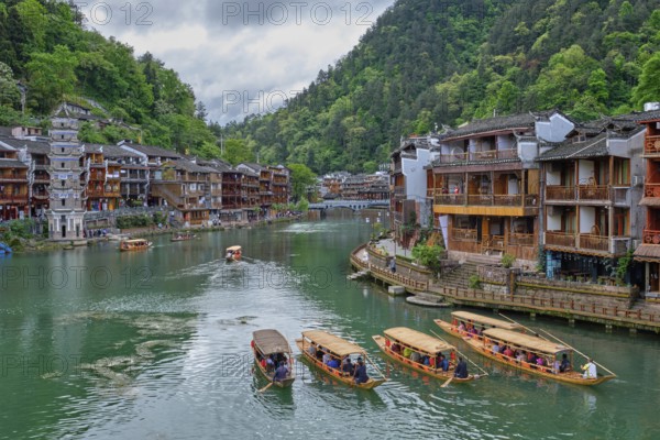Chinese tourist attraction destination, Feng Huang Ancient Town (Phoenix Ancient Town) on Tuo Jiang River with Wanming Pagoda tower and tourist boats. Hunan Province, China, Asia